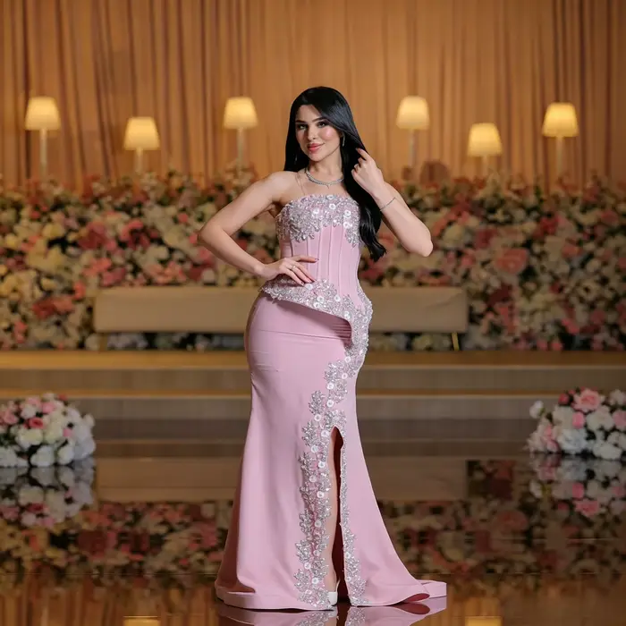 Robe de soirée élégante avec un décolleté droit sans bretelles, une détail asymétrique en peplum orn