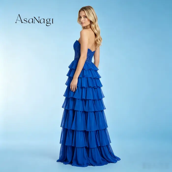 La mariée portait une robe de soirée bleue longue jusqu'au sol, sans bretelles, à volants superposés, avec de magnifiques broderies de perles.