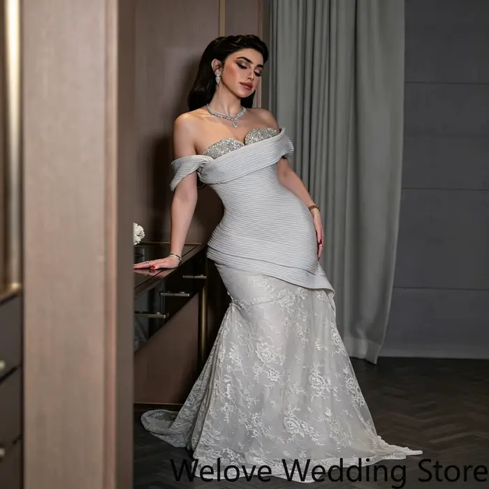 Robe de soirée élégante avec un décolleté épaules dénudées, un corsage structuré orné de cristaux et